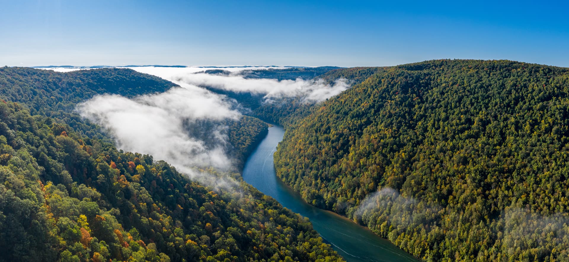 Aerial view of a river winding through forested hills